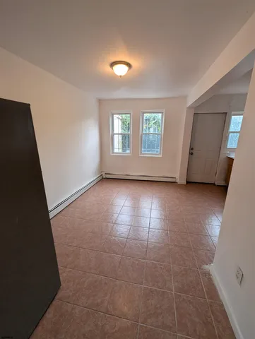 en empty room with windows and fireplace