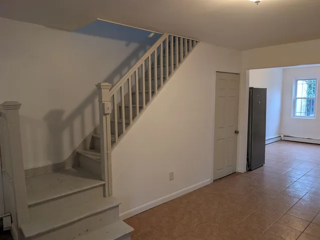 a view of hallway with stairs and wooden floor