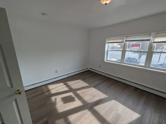 a view of a room with wooden floor and windows