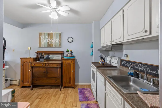 a kitchen with stainless steel appliances granite countertop a sink dishwasher and cabinets with wooden floor