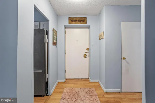 a view of a hallway with wooden floor and closet