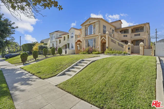 a front view of a residential apartment building with a yard
