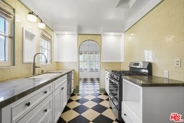 a kitchen with stainless steel appliances granite countertop a sink stove and cabinets