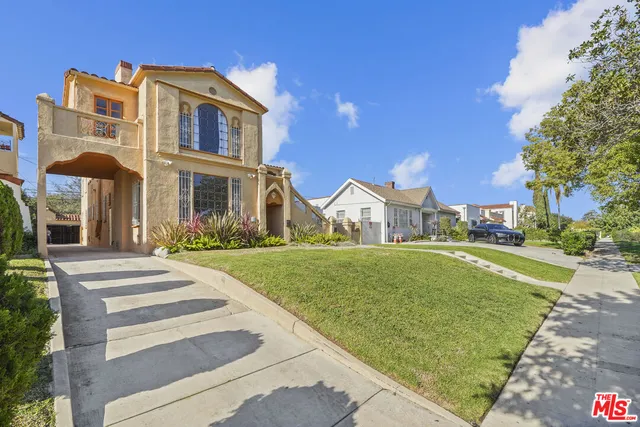 a front view of a house with a garden and yard