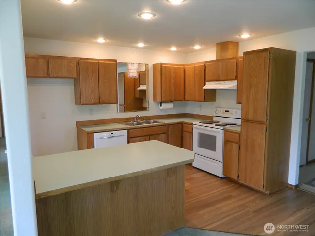 a kitchen with stainless steel appliances a sink a stove a refrigerator and cabinets