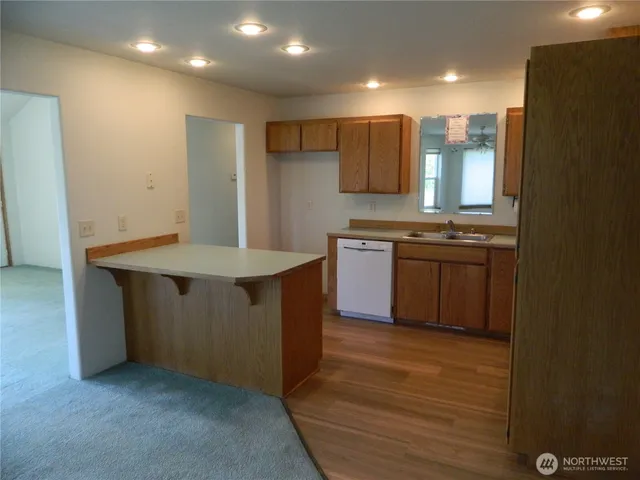 a kitchen with stainless steel appliances granite countertop a sink a stove and a refrigerator