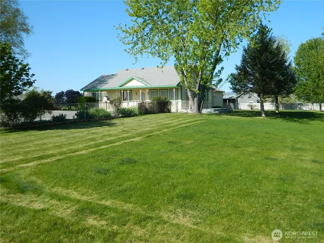 a yellow house sitting in middle of the grass