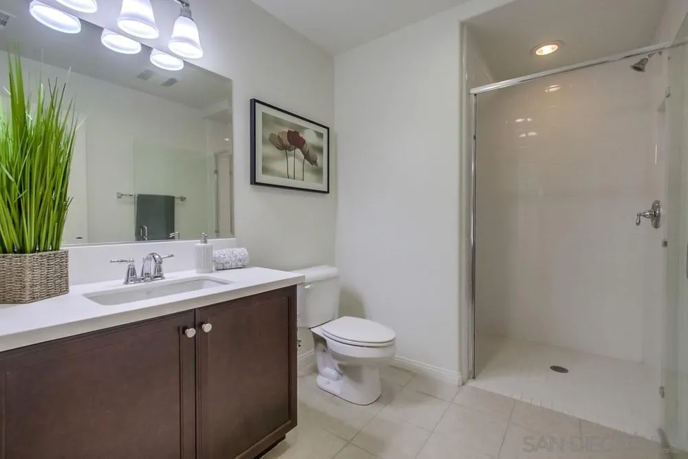 16629 Gill Loop San Diego, CA 92127 - Photo 12 of 25 a bathroom with a toilet a sink a mirror a vanity and shower