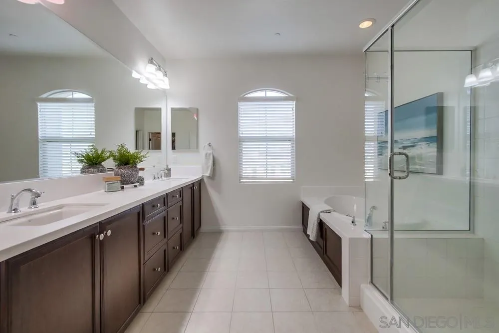 16629 Gill Loop San Diego, CA 92127 - Photo 17 of 25 a spacious bathroom with a double vanity sink a large mirror and a bathtub