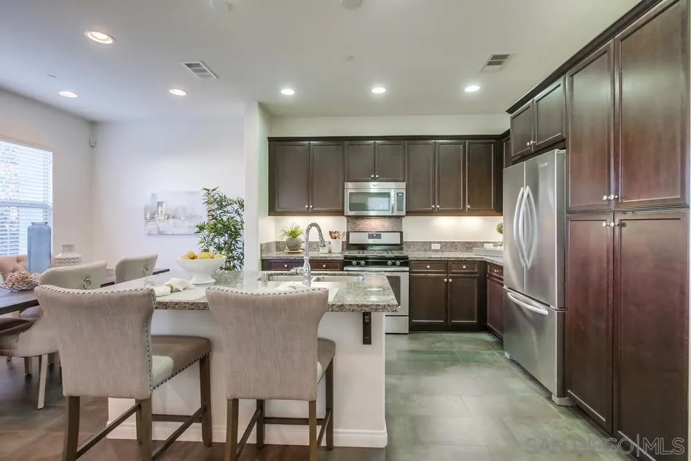 16629 Gill Loop San Diego, CA 92127 - Photo 8 of 25 a kitchen with a refrigerator and a dining table