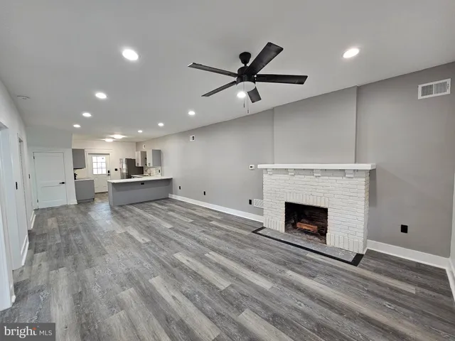 a living room with a fireplace and a ceiling fan