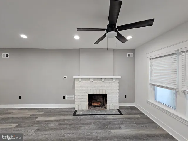 a large bedroom with a bed and wooden floor