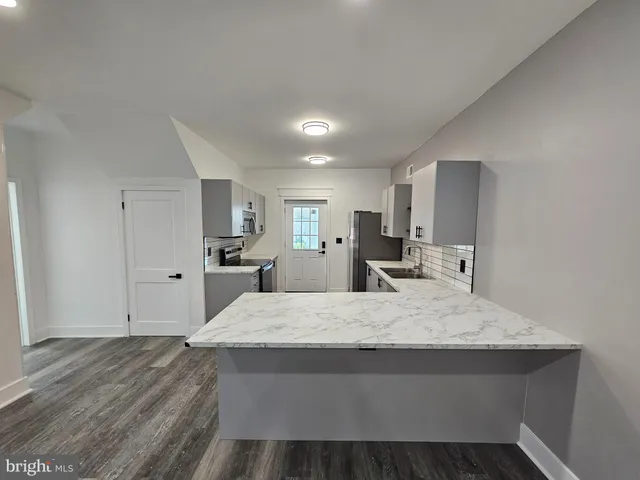 a large kitchen with stainless steel appliances lots of counter space and a sink