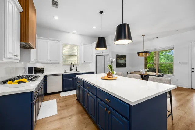 a kitchen with stainless steel appliances a stove a microwave and a cabinets