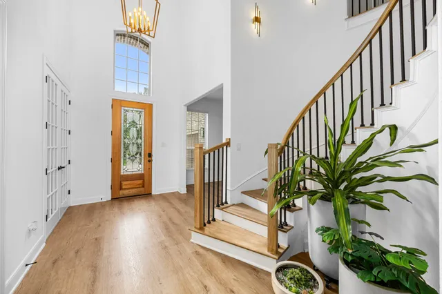 a bedroom with a bed large window with table and chair