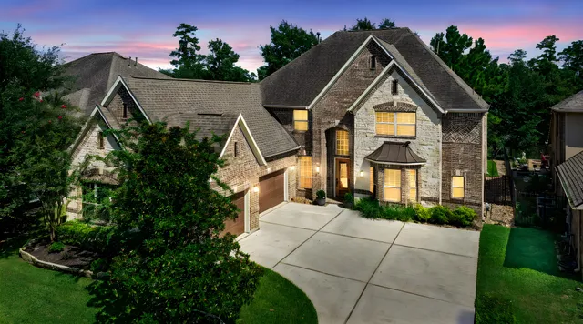 an aerial view of a house with a yard and lake view