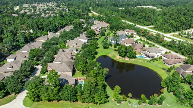 a front view of a house with a garden and trees
