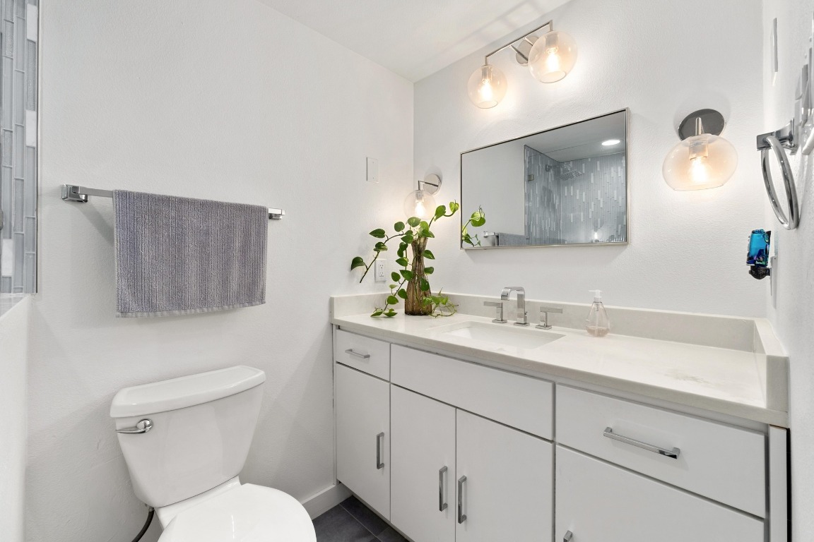 1801 Lavaca Street, Unit 7B Austin, TX 78701 - Photo 14 of 40 a bathroom with a toilet sink and mirror