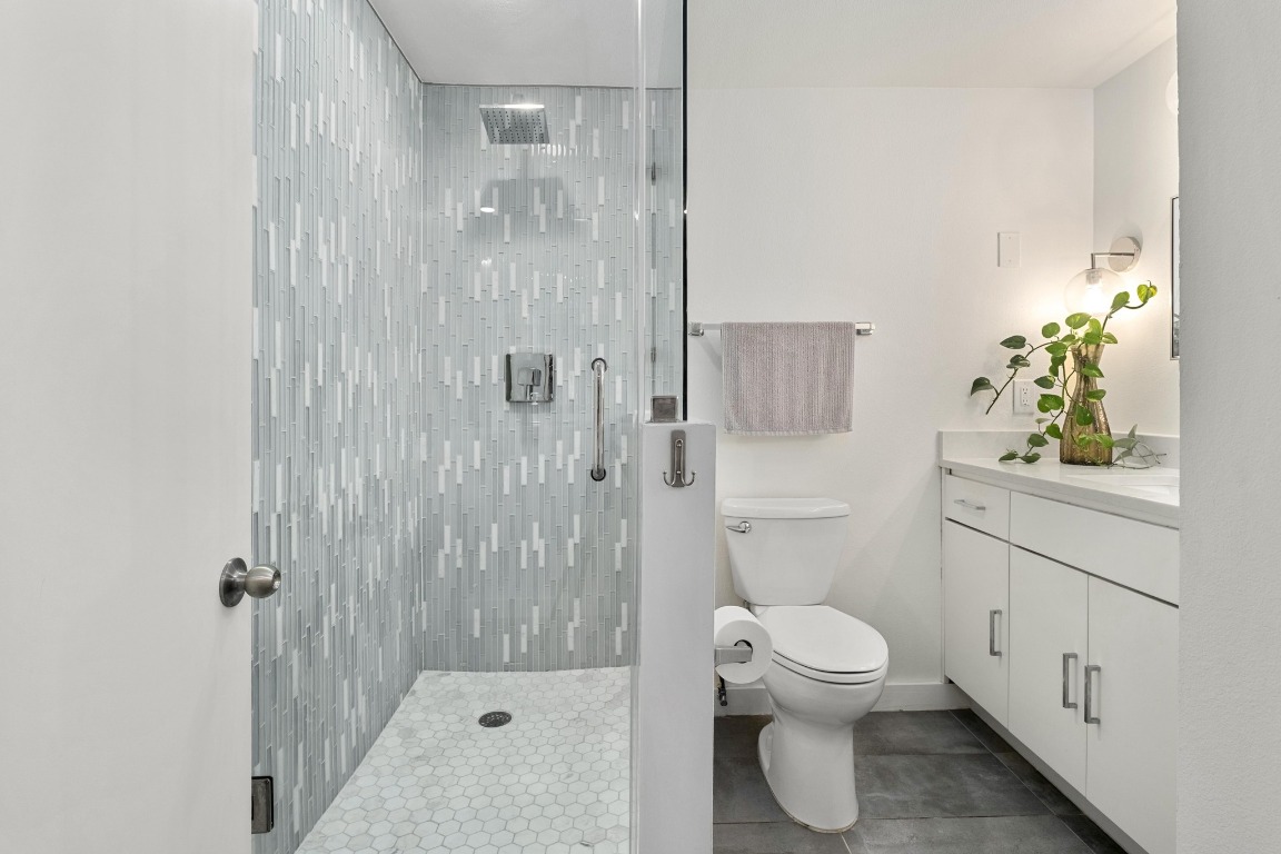 1801 Lavaca Street, Unit 7B Austin, TX 78701 - Photo 15 of 40 a bathroom with a toilet a sink and shower