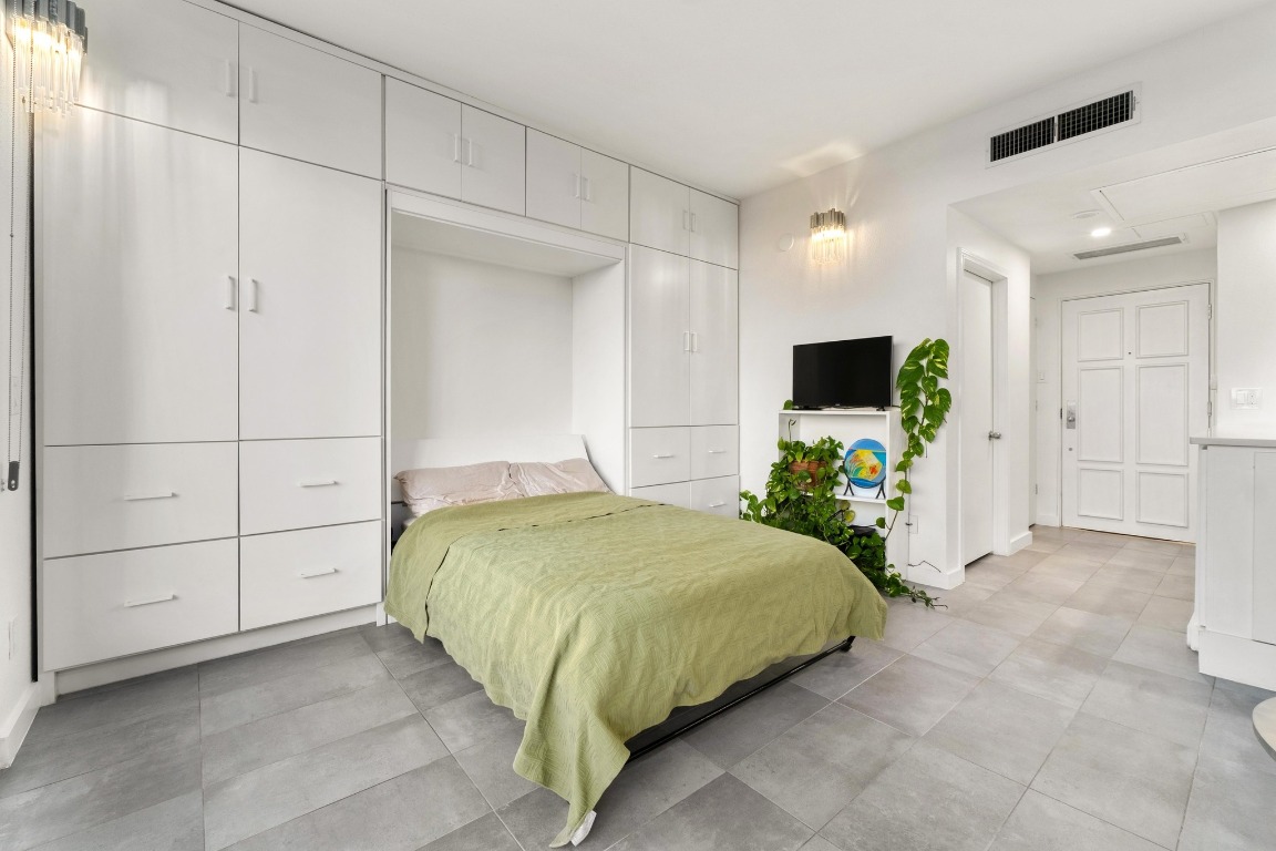 1801 Lavaca Street, Unit 7B Austin, TX 78701 - Photo 9 of 40 a bedroom with a bed and a flat screen tv