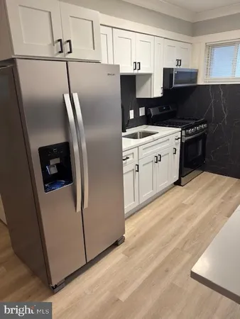 a kitchen with stainless steel appliances a refrigerator sink and cabinets