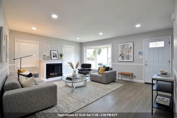 an empty room with wooden floor fireplace and windows