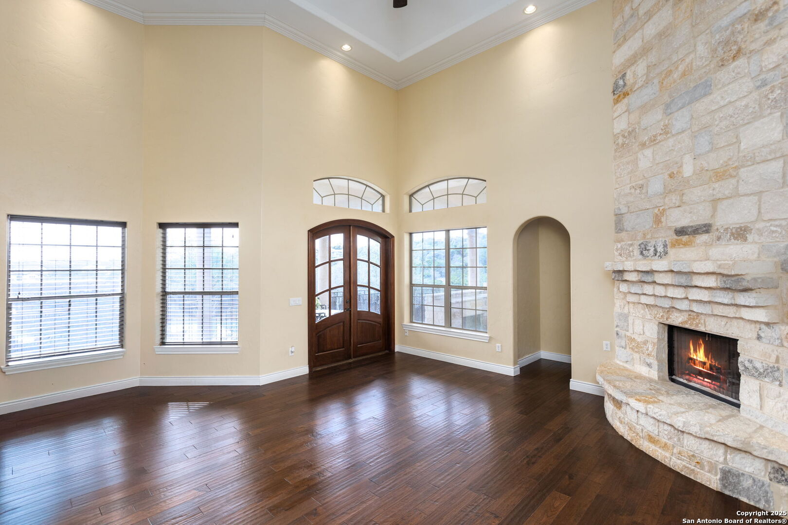 192 County Road 2812 Mico, TX 78056 - Photo 24 of 47 an empty room with windows fireplace and wooden floor