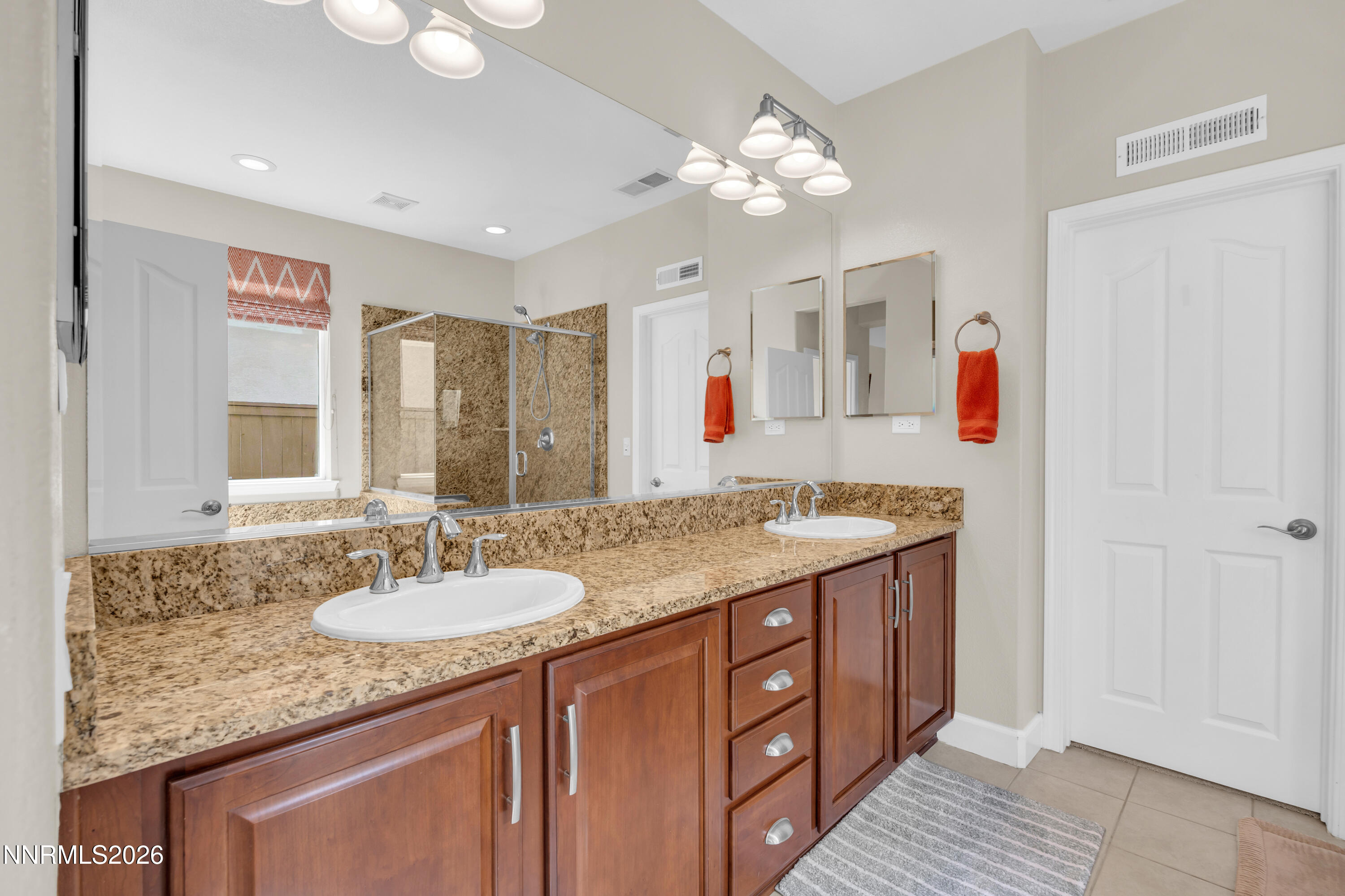 7119 Coldwater Street Sparks, NV 89436 - Photo 33 of 45 a bathroom with a granite countertop sink a large mirror and a shower