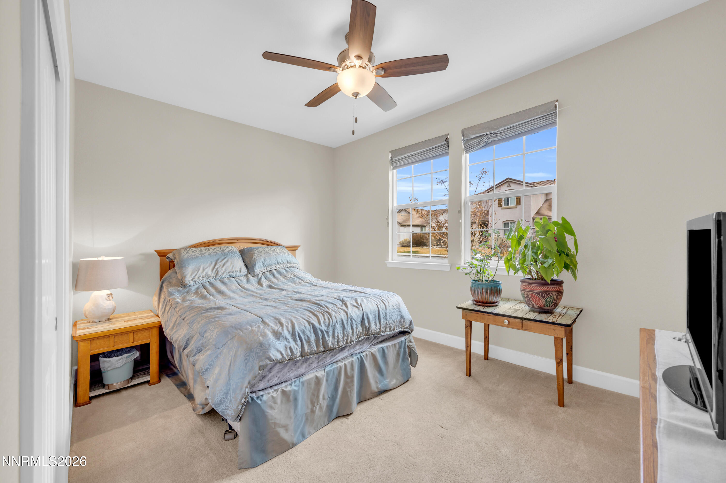 7119 Coldwater Street Sparks, NV 89436 - Photo 36 of 45 a bedroom with a bed a computer on a desk and a potted plant