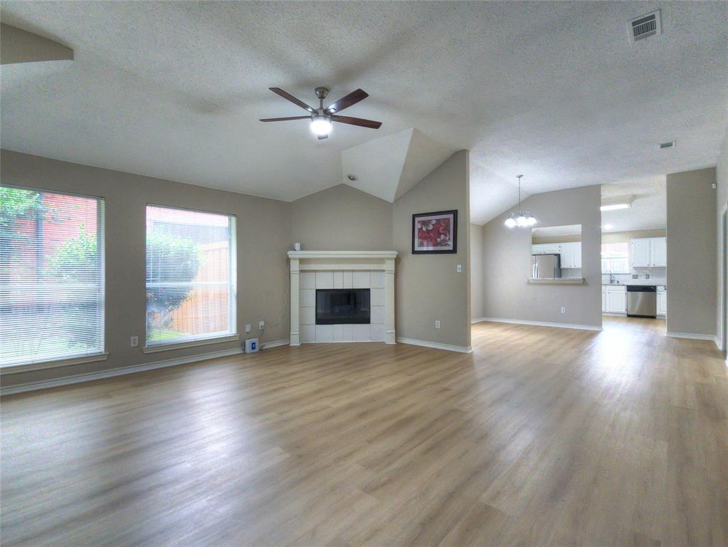 12000 Port Road Frisco, TX 75035 - Photo 15 of 40 Open concept living area with wood-finish flooring, a vaulted ceiling, and a ceiling fan