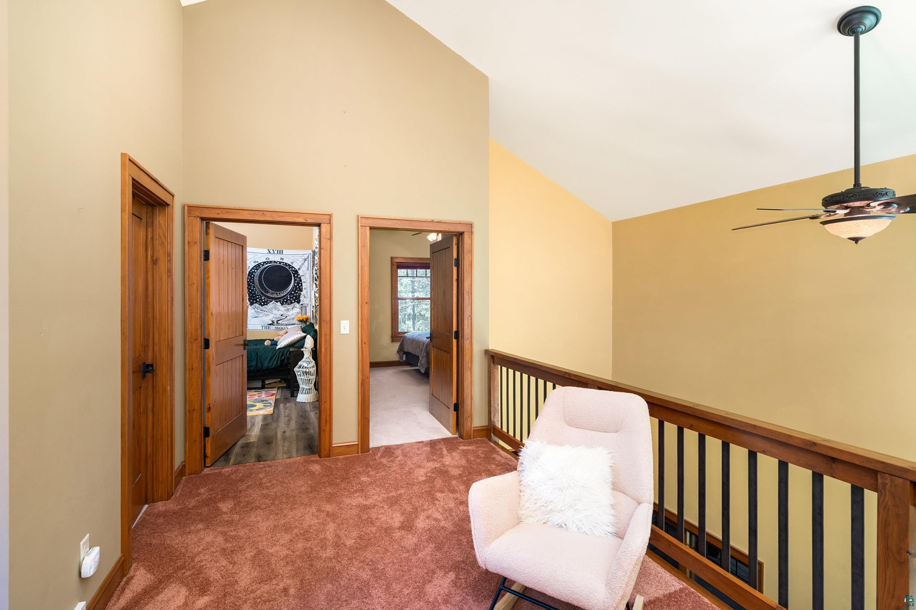 75 East Stark Road Esko, MN 55733 - Photo 30 of 87 Loft area featuring vaulted ceilings, a wood and iron baluster railing, and two panel wood doors