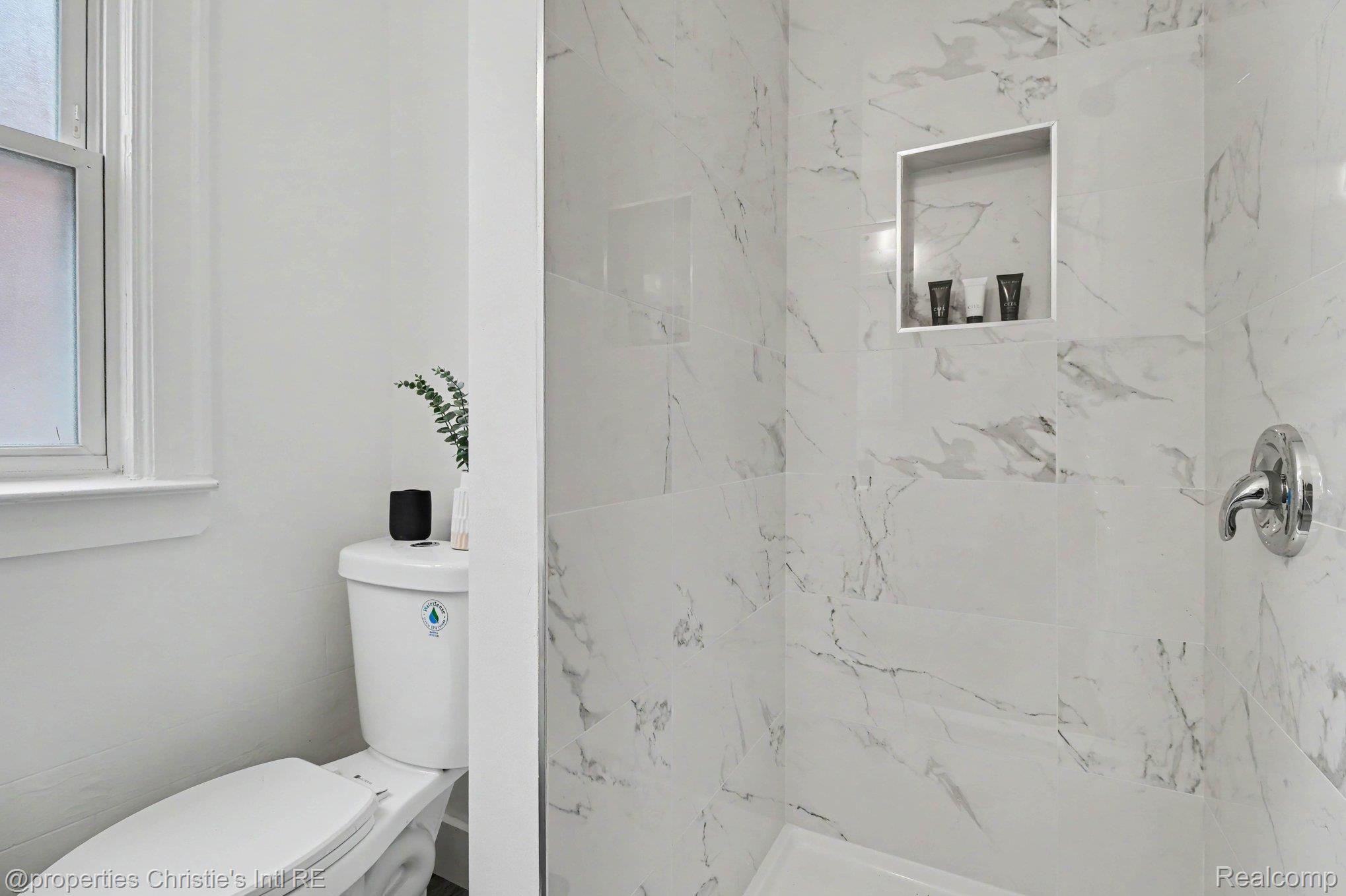 18315 Prairie Street Detroit, MI 48221 - Photo 13 of 16 Shower featuring marble-look tile, built-in recessed niche, and polished chrome fixtures