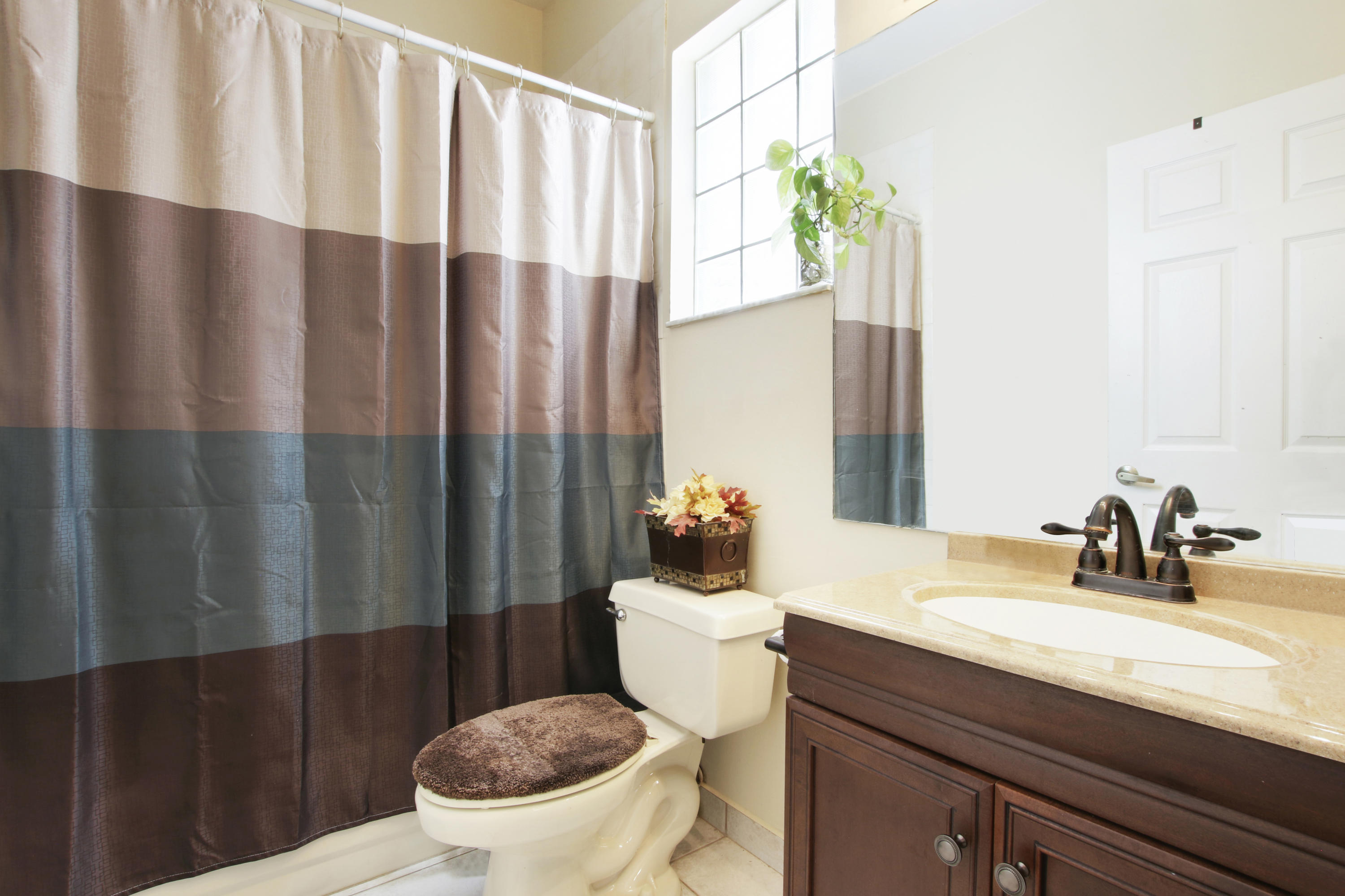 22048 Altona Drive Boca Raton, FL 33428 - Photo 19 of 33 a bathroom with a sink a toilet and shower curtain