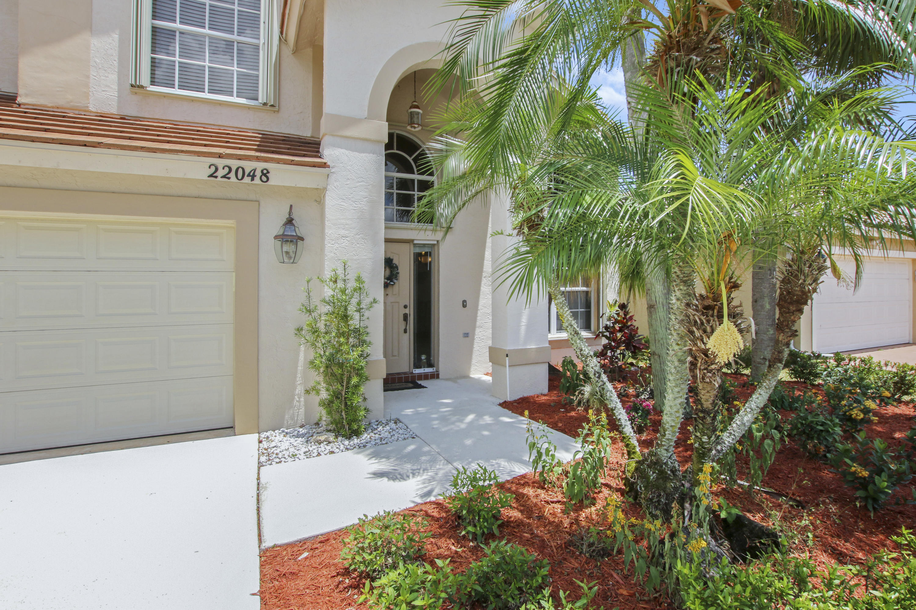 22048 Altona Drive Boca Raton, FL 33428 - Photo 4 of 33 a view of a house with a small yard and potted plants