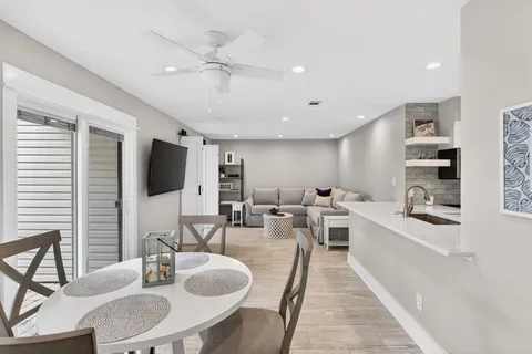 a living room with furniture a flat screen tv and kitchen view