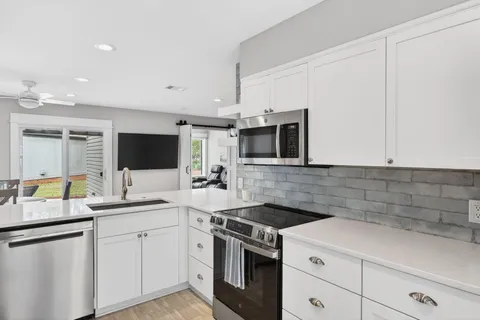 a kitchen with stainless steel appliances a sink stove and microwave