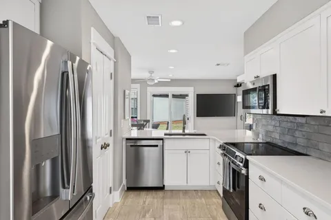 a kitchen with stainless steel appliances a refrigerator sink and microwave