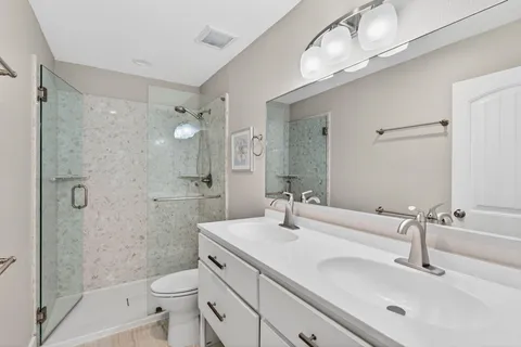 a bathroom with a sink a toilet and shower