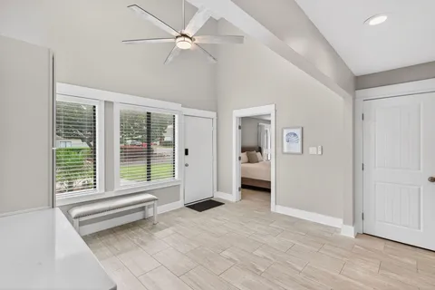 a view of a room with a large window and wooden floor
