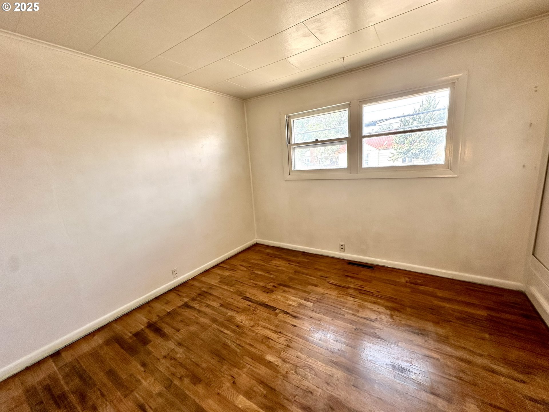 2460 Clark Street Baker City, OR 97814 - Photo 16 of 46 a view of an empty room with wooden floor and a window