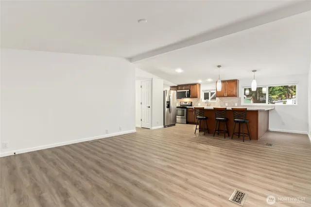 a living room with kitchen furniture and a wooden floor