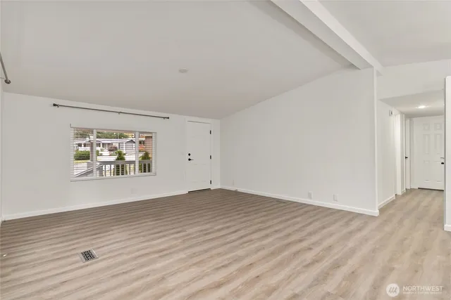 an empty room with wooden floor and window