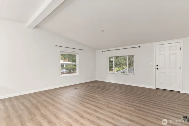 a kitchen with stainless steel appliances a sink a stove a refrigerator cabinets and wooden floor