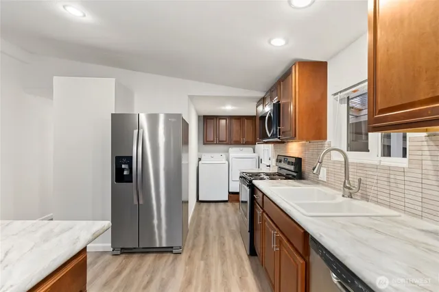 a kitchen with granite countertop a sink stove and cabinets