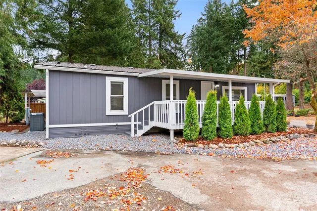 a view of a small yard in front of a house with a large tree