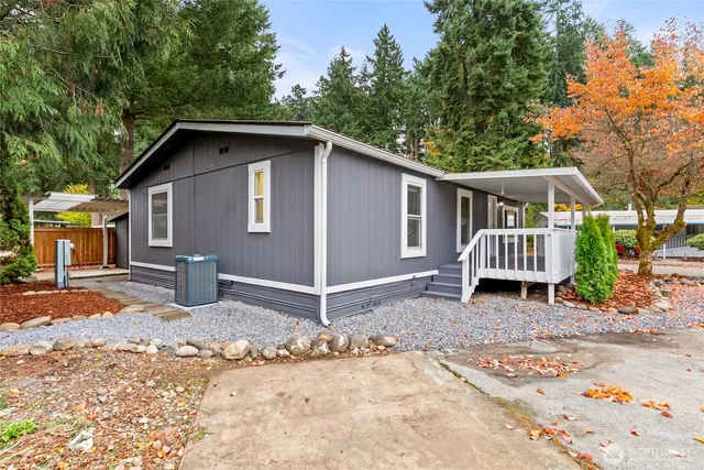 a view of a house with a yard siting area and trees around