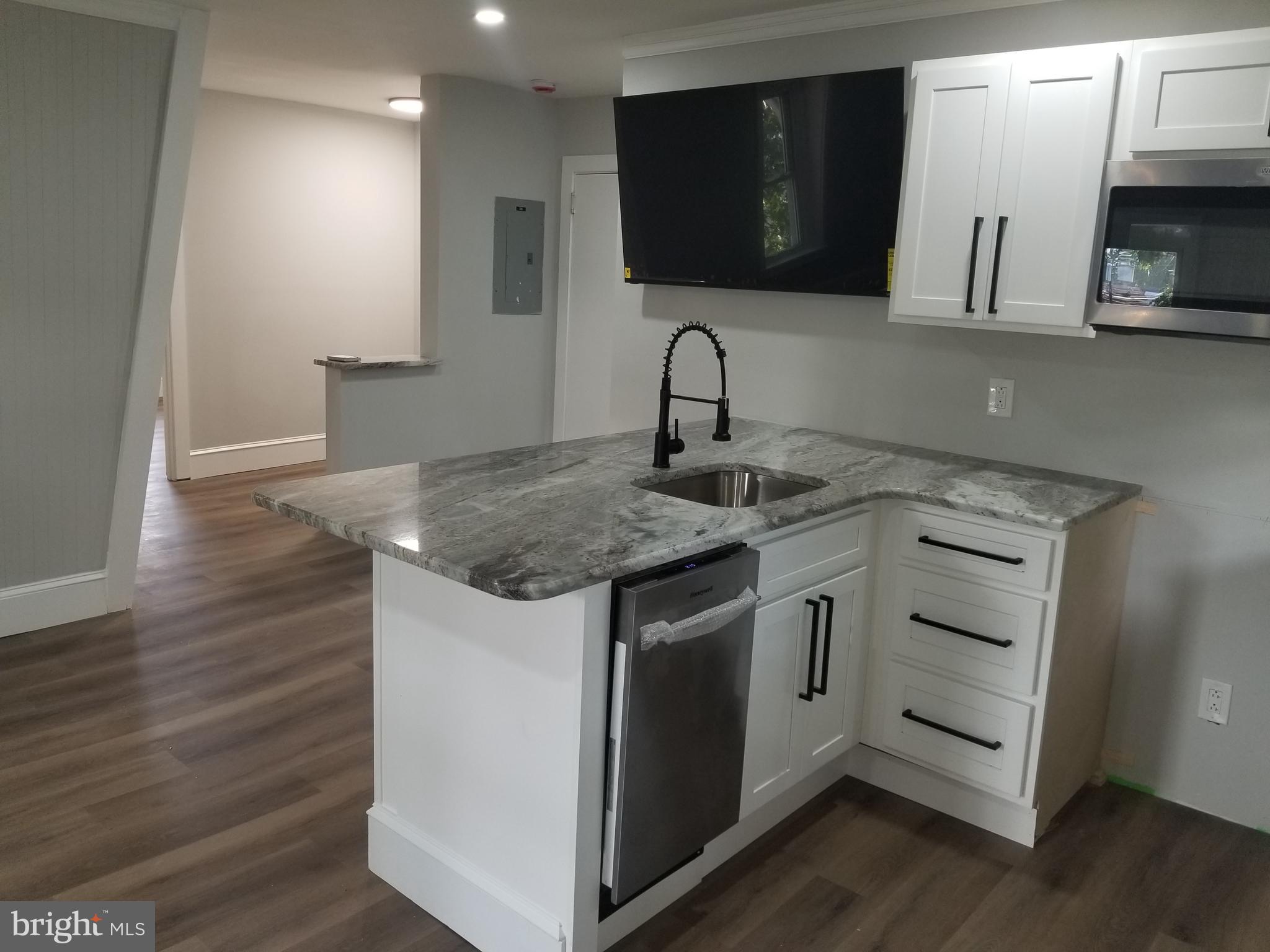 212 Warren Street Beverly, NJ 08010 - Photo 23 of 33 a kitchen with stainless steel appliances granite countertop a sink stove and microwave
