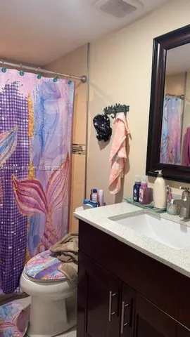 a bathroom with a sink toilet and mirror