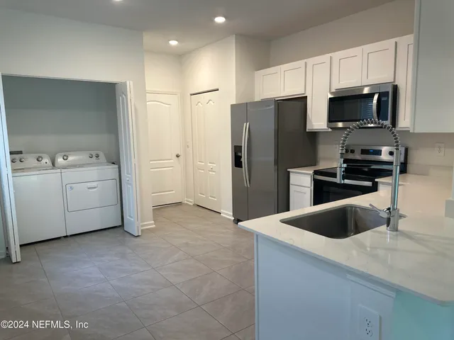 a kitchen with stainless steel appliances a refrigerator a sink a stove and cabinets
