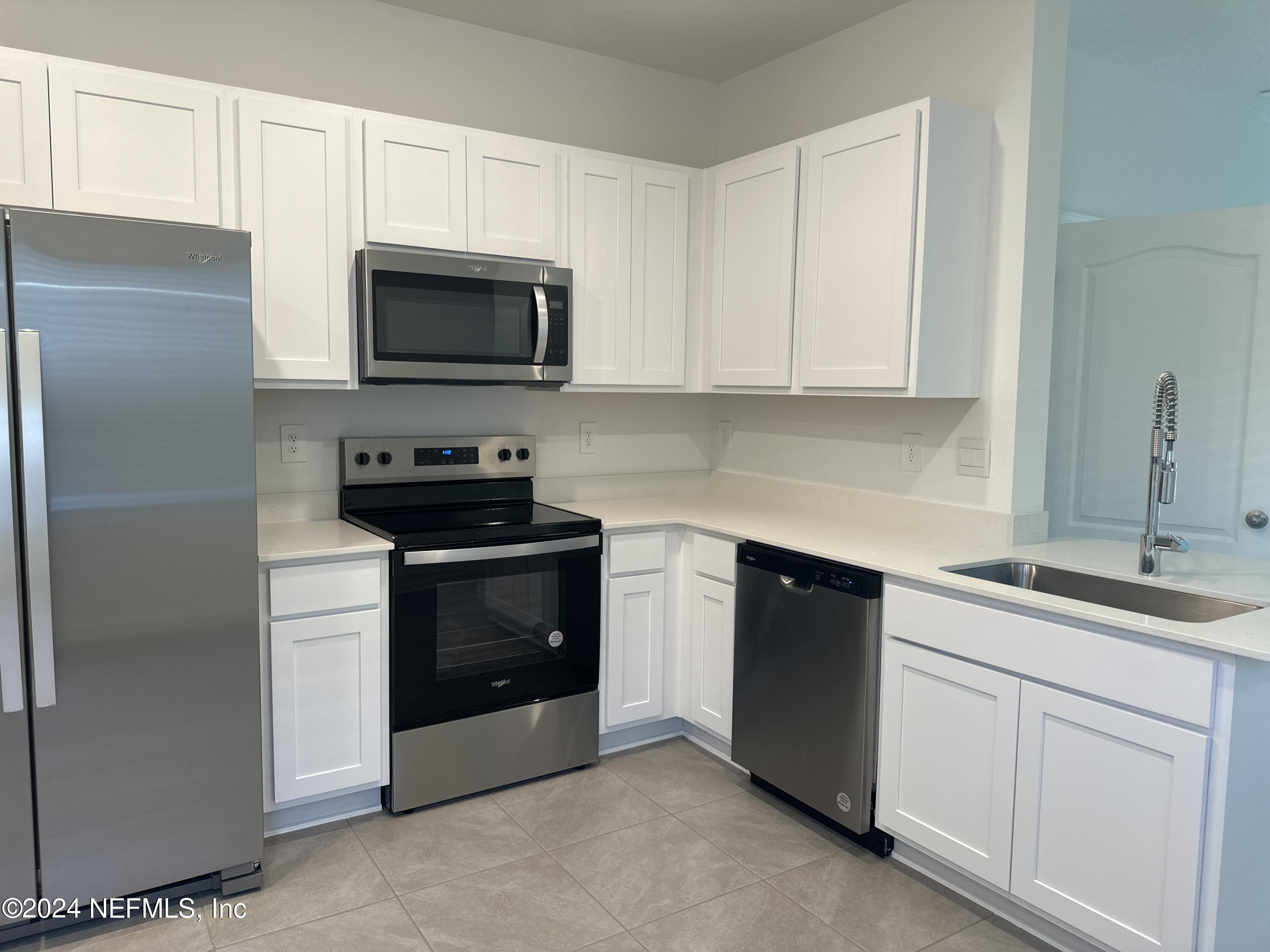 168 Tidal Bch Avenue St. Augustine, FL 32095 - Photo 3 of 36 a kitchen with white cabinets and stainless steel appliances